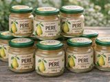 six pots de beurre de poire posés sur une table en bois