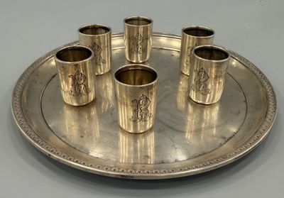 un plateau en argent sur lequel sont posées six tasses en argent