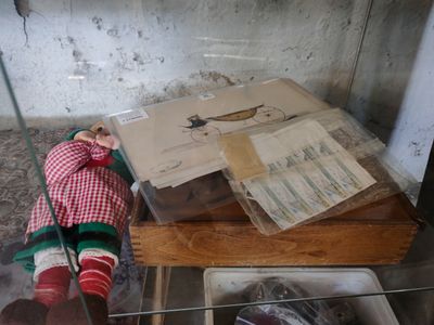 une poupée posée sur une table dans une vitrine