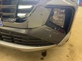 the front bumper of a silver truck with a license plate on it ' s bumper