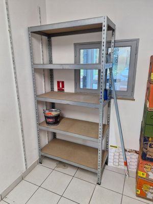 une étagère comportant de nombreuses tablettes, placée dans un coin de la pièce