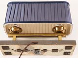 an old radio sitting on top of a piece of luggage