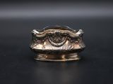 a close up of a silver ring on a black surface