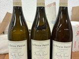 trois bouteilles de vin posées sur une table en bois