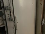 un réfrigérateur blanc dans le coin d'une pièce