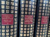 a lot of books that are lined up on a shelf
