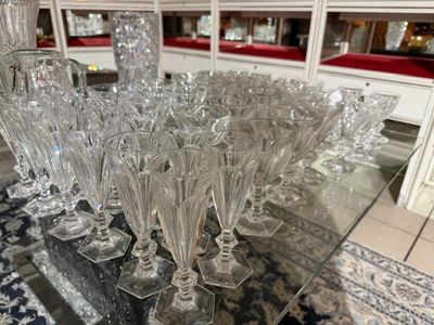 a lot of wine glasses sitting on a glass table
