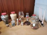 une table sur laquelle sont disposés de nombreux bocaux et des bougies