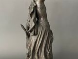 a statue of a woman with a bird on her shoulder