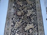 un tapis posé à même le sol, dans un coin d'une pièce aux murs blancs