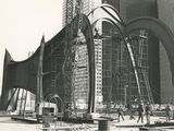 photo en noir et blanc montrant des ouvriers du bâtiment travaillant sur un grand chantier