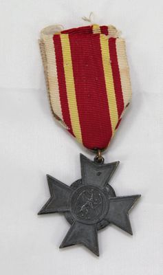 une vieille médaille ornée d'une étoile, posée sur une surface blanche