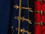 a close up of a coat with gold buttons and a red jacket