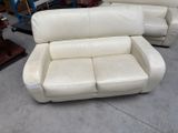 a white leather couch and chair in a warehouse