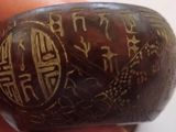 a close up of a person holding a stone with writing on it