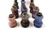 a lot of different colored vases on a white surface