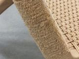 the seat of a wooden chair with a woven seat pad on it