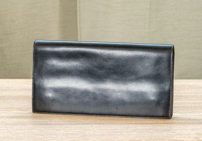 un portefeuille en cuir noir posé sur une table en bois