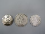 trois types différents de pièces d'argent sur une surface grise