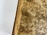 an old book sitting on top of a table next to a white wall