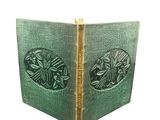 un vieux livre avec une couverture verte sur laquelle figure l'image d'un oiseau