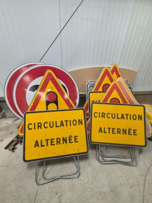 yellow and red signs sitting on top of a pile of construction materials