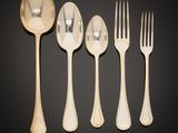a set of five forks and spoons on a black background