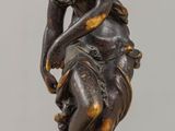 statue en bronze représentant une femme tenant un oiseau sur une table en bois