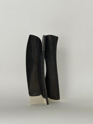 une paire de bottines en cuir noir posées sur une surface blanche