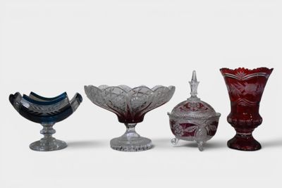 several different colored glass vases are lined up on a white surface