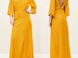 a woman wearing a yellow dress with open back and open shoulders