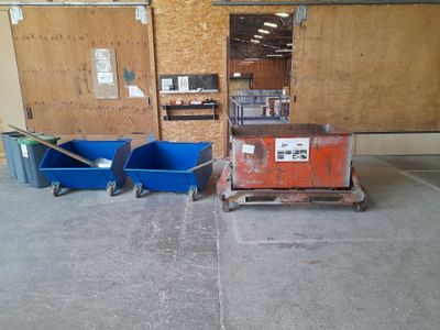 two blue bins and a cart in a garage