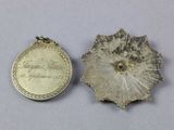two pieces of silver are shown next to each other on a white surface