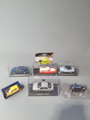 six toy cars in a display case on a table