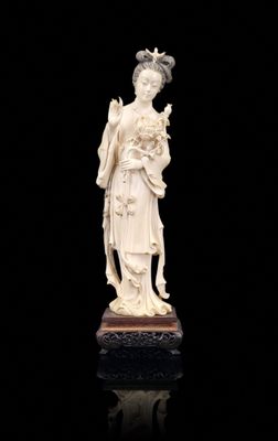 a white statue of a woman holding a flower on a black surface