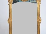 un miroir au cadre doré richement décoré, dont le bord est orné d'un motif élaboré