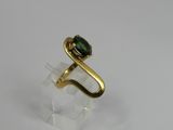 a close up of a gold ring with a green stone