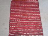 an image of a red and white rug on the floor