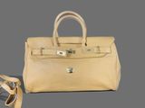 an image of a beige leather handbag on a gray background