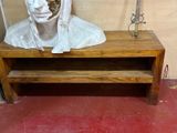 une statue représentant un homme assis sur un banc en bois
