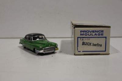 une petite voiture verte en plastique posée à côté d'une petite boîte