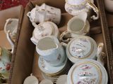 a box full of tea cups and saucers on the floor