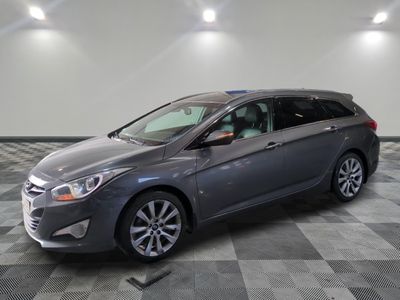 Une voiture grise est garée sur un sol à damier dans un garage.