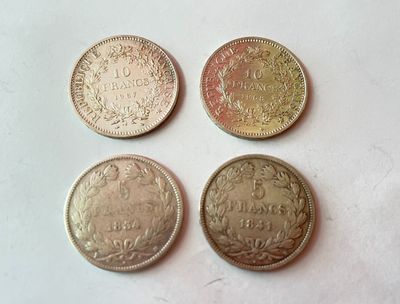 quatre types de pièces différents posés sur une surface blanche