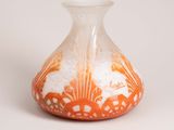 an orange and white vase sitting on a white surface