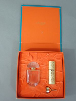 an orange box containing a bottle of perfume and a lighter