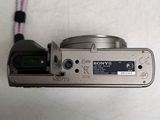 a silver camera with a cord attached to it