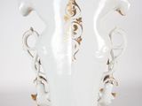 a white vase with a gold decoration on it