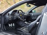 the interior of a black sports car with its door open