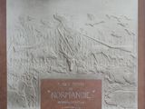 une plaque fixée au mur d'un immeuble, sur laquelle figure la photo d'un homme et d'un chien